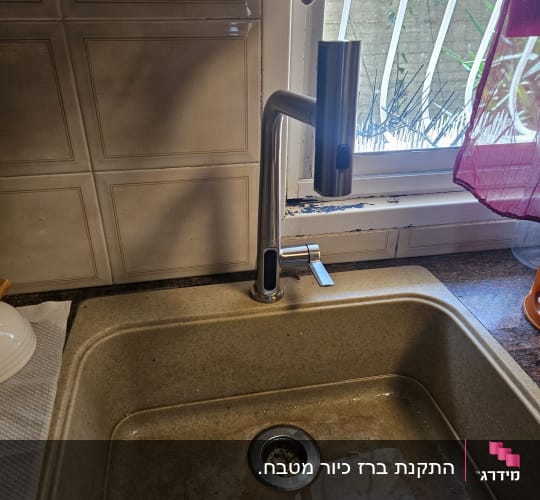 ברז וכיור במטבח עם מים בכיור